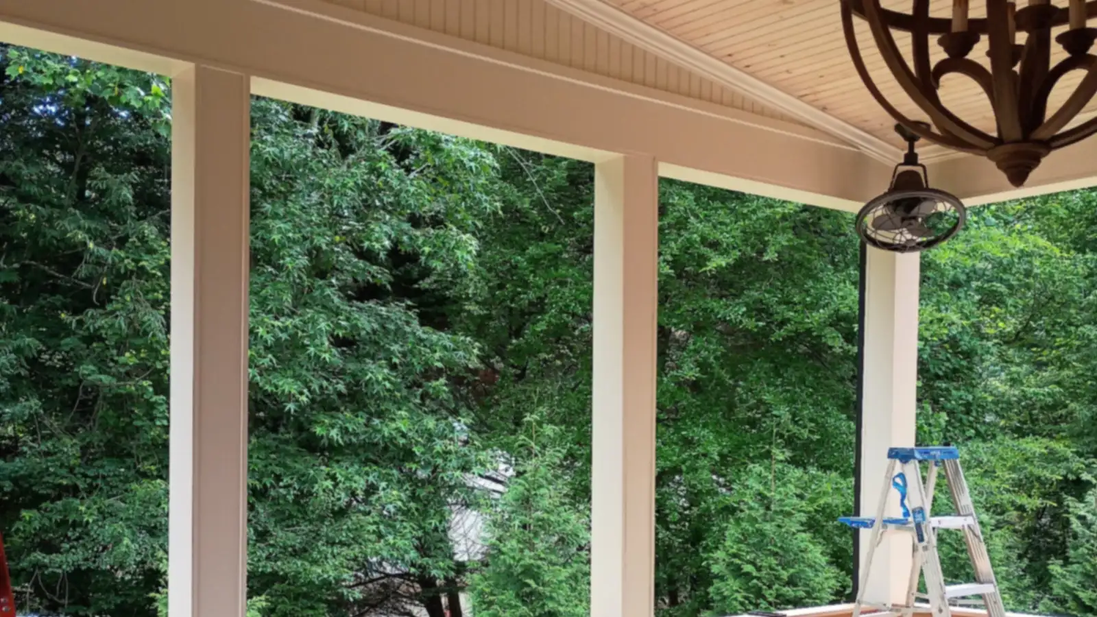 Wheeler Painting painter working on a screened porch surrounded by trees