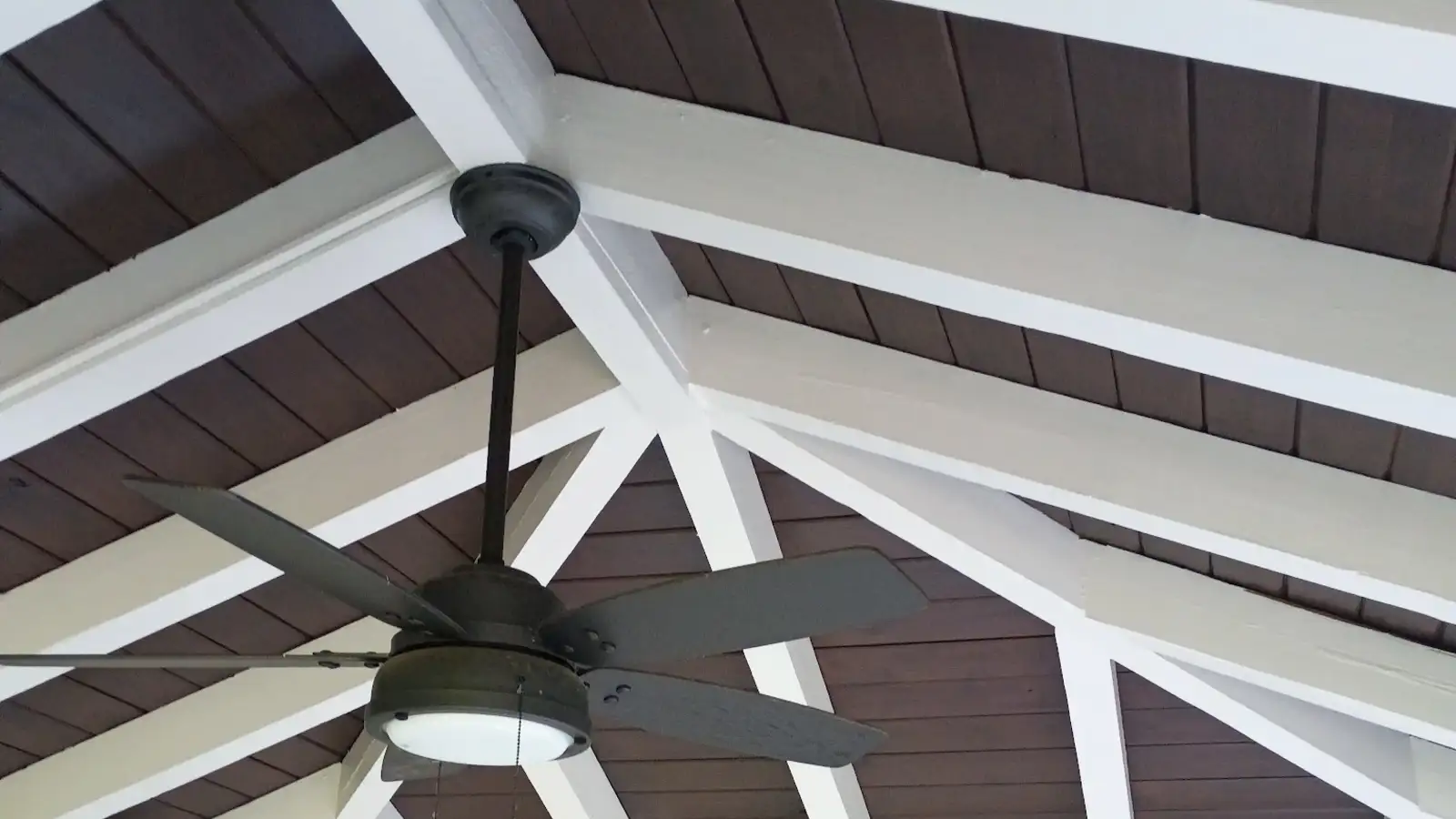 White painted beams and a stained wood ceiling on a covered porch, from a Wheeler Painting exterior project