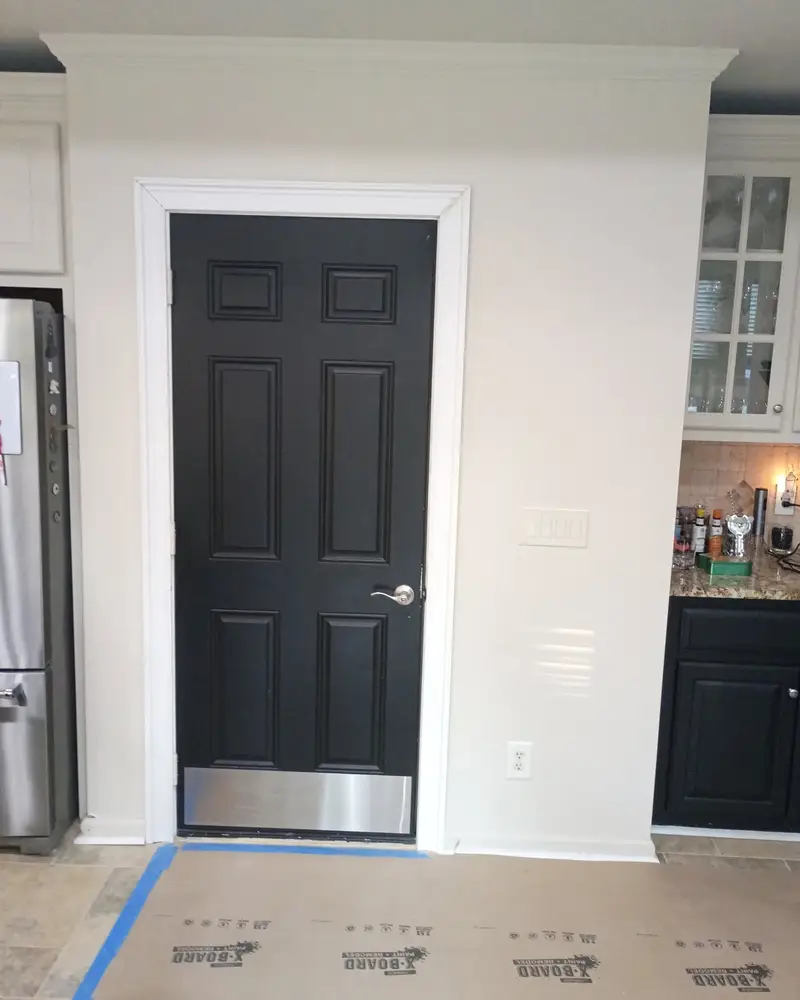 Interior door painted black with crisp white trim, from a Wheeler Painting project