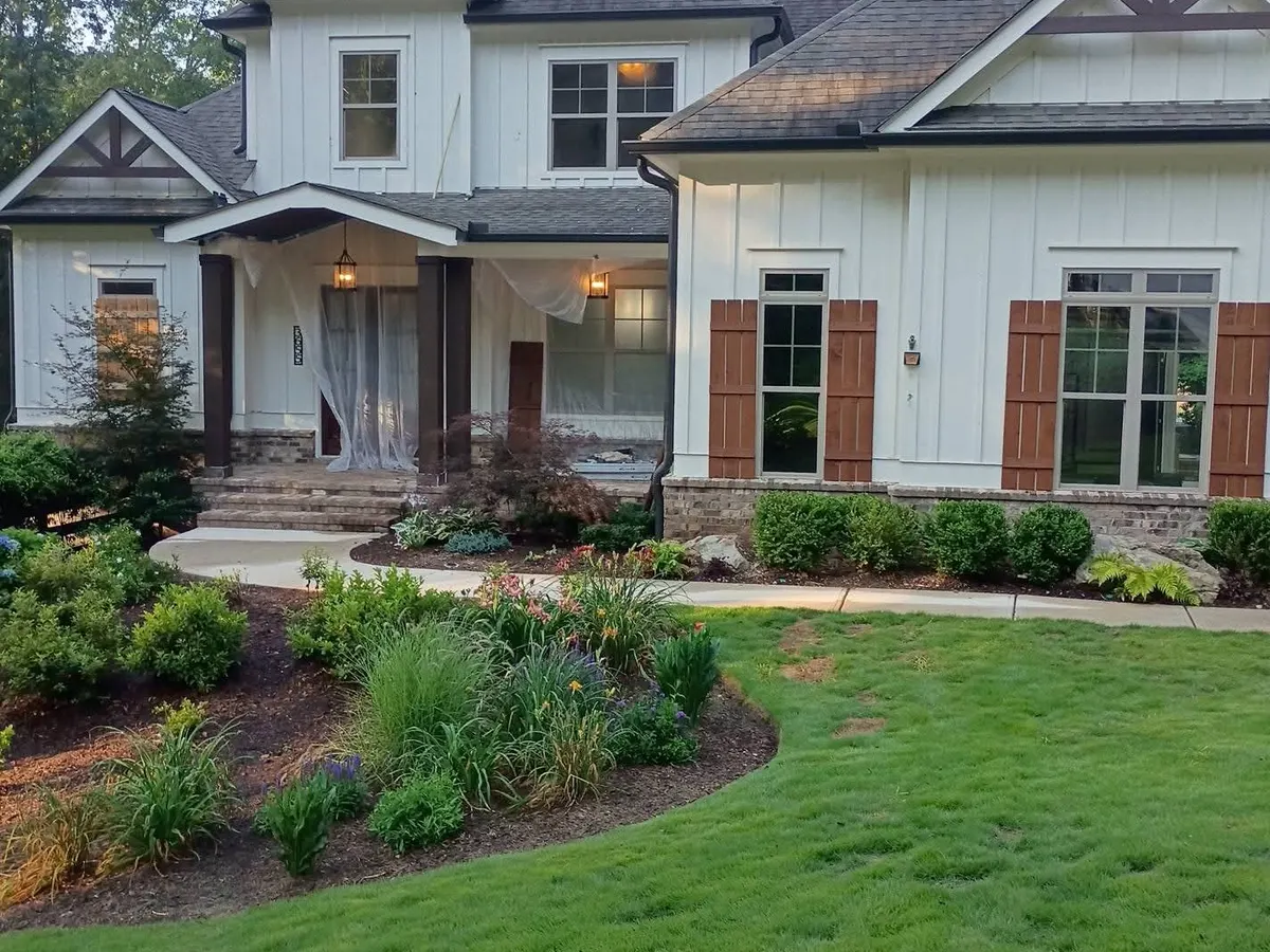 White craftsman home exterior with dark trim mid-paint, protection on the porch