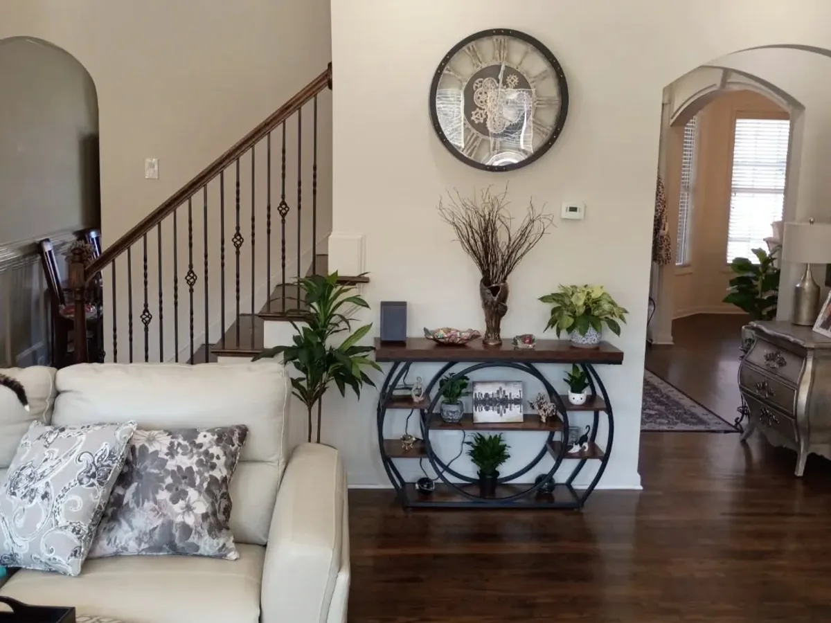 Finished living room with white walls, arched openings and a dark-wood staircase